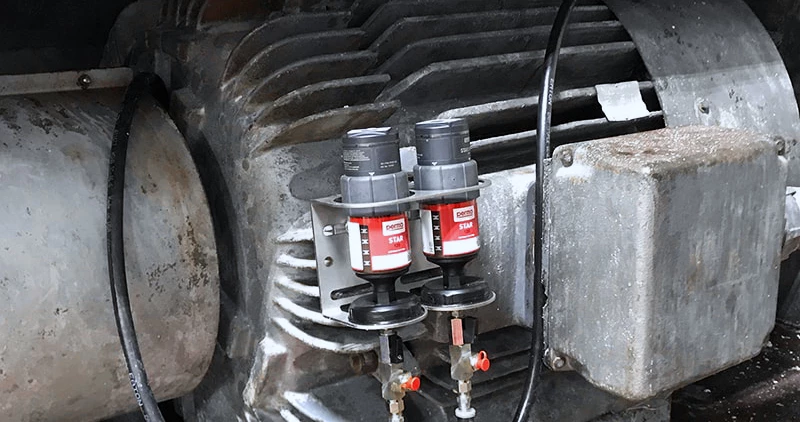 two perma STAR VARIO automatic greasers mounted to heavy machinery