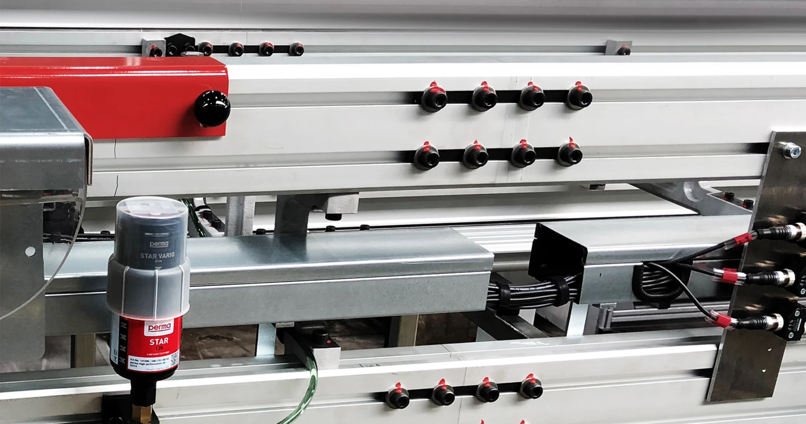 an electromechanical auto greaser remote mounted on a conveyor in an automotive manufacturing plant