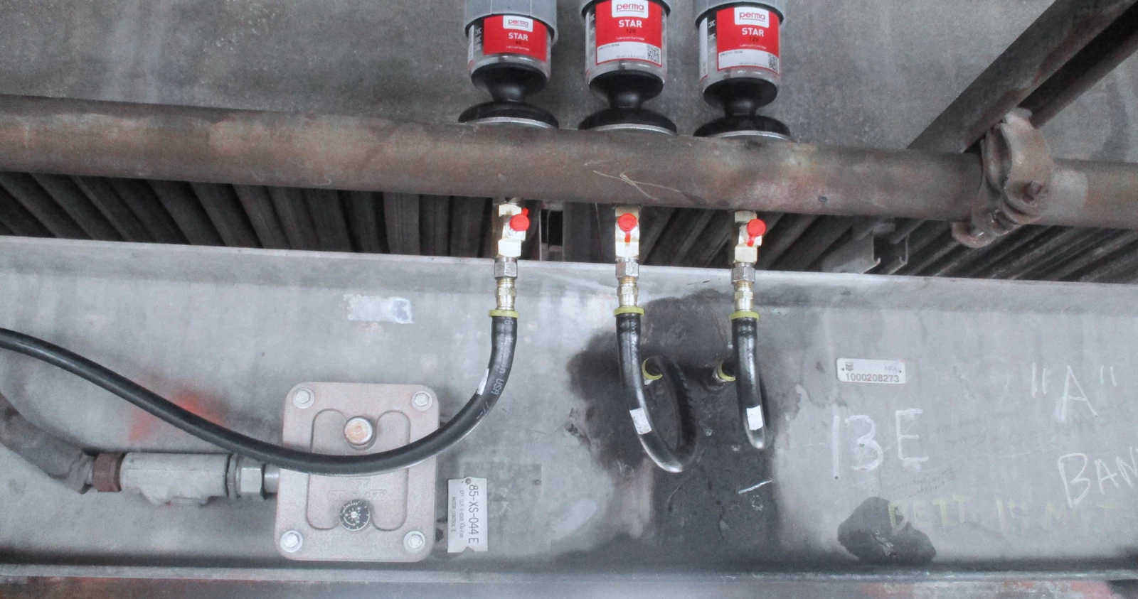 three perma STAR VARIO greasers mounted remotely to heavy industrial machinery
